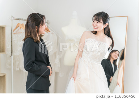 結婚式の準備でウェディングドレスの衣装合わせをするアジア人女性(試着・フィッティング) 結婚式の準備でウェディングドレスの衣装合わせをするアジア人女性(試着・フィッティング) 116350450
