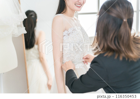 結婚式の準備でウェディングドレスの衣装合わせをするアジア人女性（お直し・フィッティング） 116350453