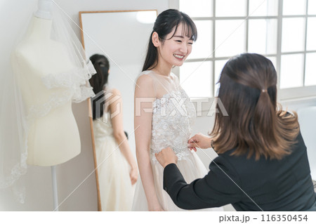結婚式の準備でウェディングドレスの衣装合わせをするアジア人女性（お直し・フィッティング） 116350454