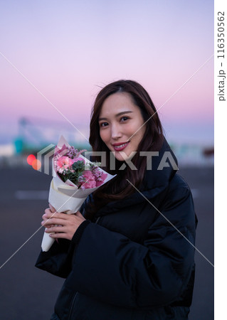 夕暮れの公園で花束を持つ女性 夕暮れの公園で花束を持つ女性 116350562