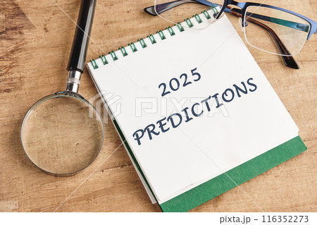 Business concept. Copy space.2025 predictions symbol on a notebook in a composition with a magnifying glass, glasses and a pencil Business concept. Copy space.2025 predictions symbol on a notebook in a composition with a magnifying glass, glasses and a pencil 116352273