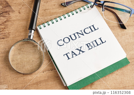 COUNCIL TAX BILL word on a notebook in a composition with a magnifying glass, glasses and a pencil COUNCIL TAX BILL word on a notebook in a composition with a magnifying glass, glasses and a pencil 116352308