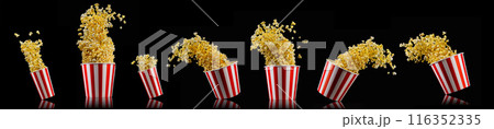 Flying popcorn from striped bucket isolated on black background Flying popcorn from striped bucket isolated on black background 116352335
