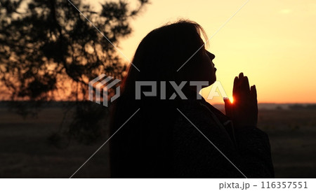 girl woman praying at sunset, hand sunset faith pain, asking heaven for help, spiritual sunset meditation, serene prayer moment, dusk reflection solitude, sunset prayer tranquility, peaceful evening 116357551