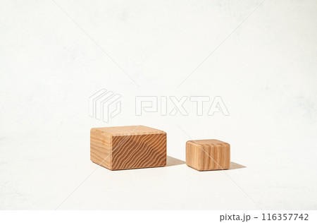 A mockup scene for presenting beauty cosmetics products, featuring textured wooden cube pedestals on a white background. 116357742