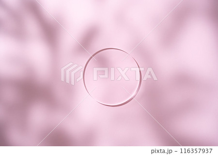 Mockup scene for a cosmetic product presentation featuring an empty glass podium in a circular shape on a pink background with leaf shadows. Mockup scene for a cosmetic product presentation featuring an empty glass podium in a circular shape on a pink background with leaf shadows. 116357937