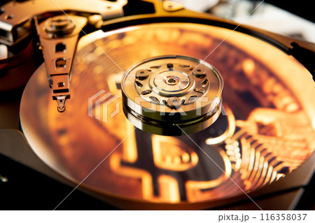 Inside of an open computer hard drive with the projected bitcoin symbol 116358037
