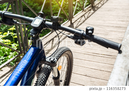 Cycling background with mountain bike fragment on the bridge. Selective focus on the bicycle wheel. 116358273
