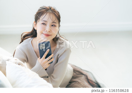 スマホを持って微笑む女性 116358628