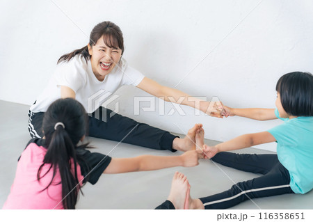 部屋で体操をする親子 116358651