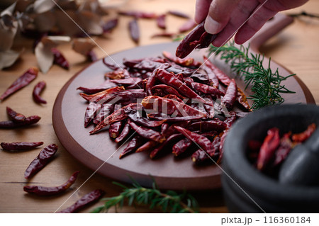 カッティングボードに置いた唐辛子（鷹の爪） 116360184