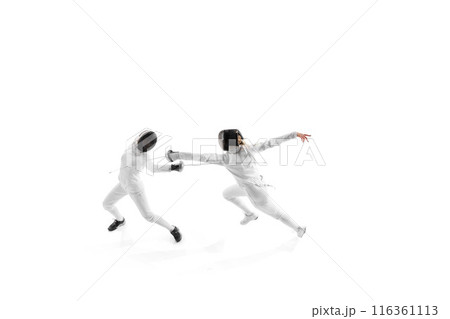 Fencing partners spar in controlled practice, each working to enhance their strategy and execution against white studio background. 116361113