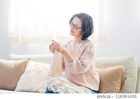 リビングで編み物をするシニア女性 116361410
