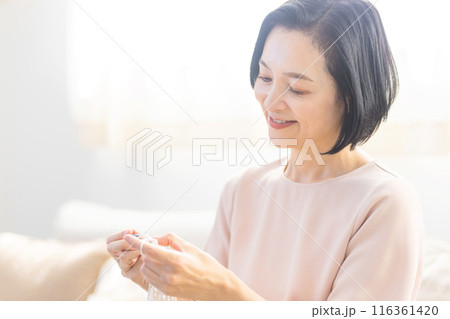 リビングで編み物をするシニア女性 116361420