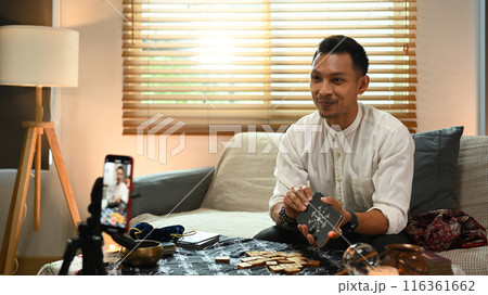 Tarot reader predicting online or recording video for blog with smartphone and ring light in foreground Tarot reader predicting online or recording video for blog with smartphone and ring light in foreground 116361662