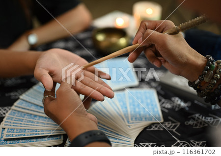 Close up fortune teller reading palm forecasting future of client in dark room. Divination concept 116361702