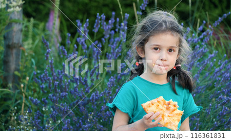 Portrait of a cute girl happily eating pizza in the backyard. Portrait of a cute girl happily eating pizza in the backyard. 116361831