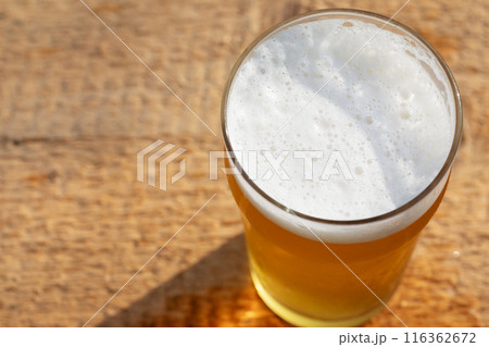 Craft beer in pint glass on a wooden surface Craft beer in pint glass on a wooden surface 116362672