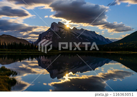 Moonrise at Vermilion Lakes in summer night. Banff National Park, Canadian Rockies, Alberta, Canada. Bright full moon over Mount Rundle and light up the night with golden reflection on lake surface. 116363051