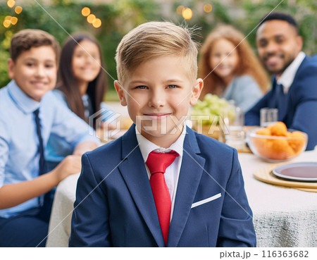 Happy Young Boy Celebrating Birthday with Family and Friends in a Backyard Party 116363682