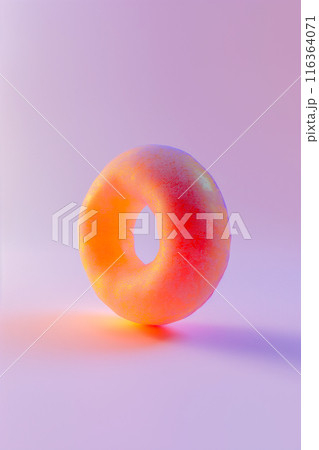 A donut with a sprinkle on top is shown on a purple background 116364071