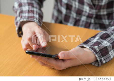 スマホを操作する人の手元のクローズアップ スマホを操作する人の手元のクローズアップ 116365591