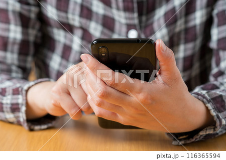 スマホを操作する人の手元のクローズアップ 116365594