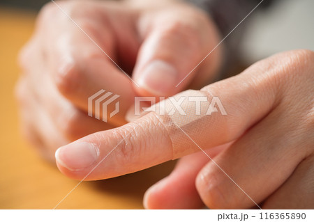 指に絆創膏を貼る人の手元 116365890
