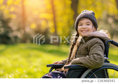 Beautiful disabled happy girl in a wheelchair in a spring park on a sunny day. Lifestyle and fresh air 116368541