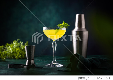 Tropical yellow lemon cocktail on green background 116370204