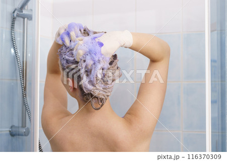 Woman applying toner shampoo on her hair Woman applying toner shampoo on her hair 116370309