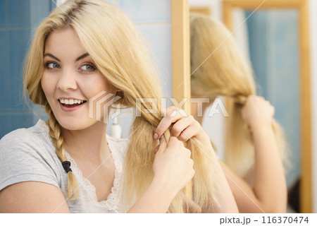 Woman making braid on blonde hair Woman making braid on blonde hair 116370474