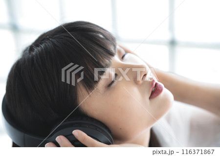 ヘッドフォンで音楽に浸る若い女性 ヘッドフォンで音楽に浸る若い女性 116371867