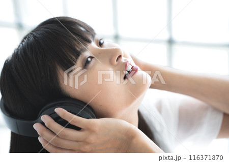 ヘッドフォンで音楽に浸る若い女性 116371870