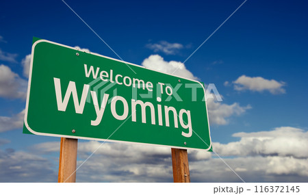 Welcome To Wyoming Green Road Sign Over Blue Sky with Some Clouds. 116372145