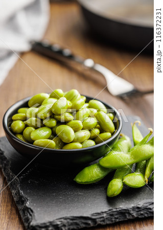Edamame soy beans in bowl on wooden table. Edamame soy beans in bowl on wooden table. 116372231