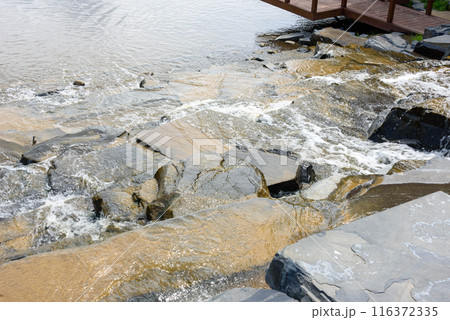 Top view of water flowing down the rocks of a cascading waterfall. 116372335