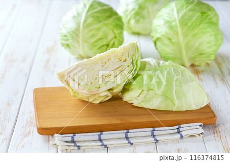 Whole and quarter green cabbage on a wooden table, 116374815