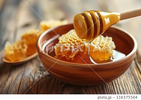 Honeycombs with honey in bowl on wooden table, closeup 116375504