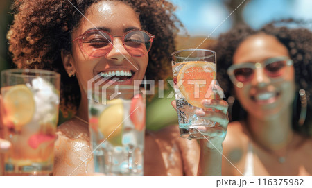 A group of friends relaxing by the pool with colorful cocktails, enjoying a sunny day  116375982