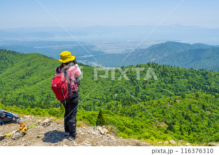 武奈ヶ岳山頂から、琵琶湖を見下ろす登山者（滋賀県大津市北比良)※作品コメント欄に撮影位置 116376310