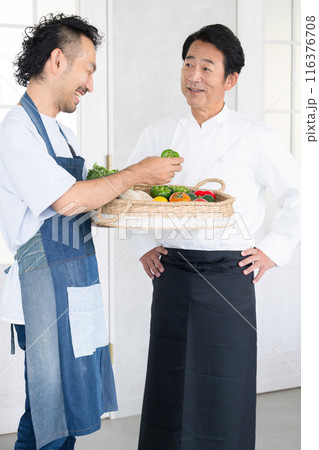 農家からお届けする野菜をチェックするシェフ　農家と直接契約や取引するコックコートを着た料理人 116376708