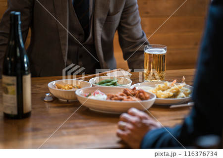 居酒屋・飲み屋で部下と楽しくお酒を飲むビジネスマンの男性 居酒屋・飲み屋で部下と楽しくお酒を飲むビジネスマンの男性 116376734