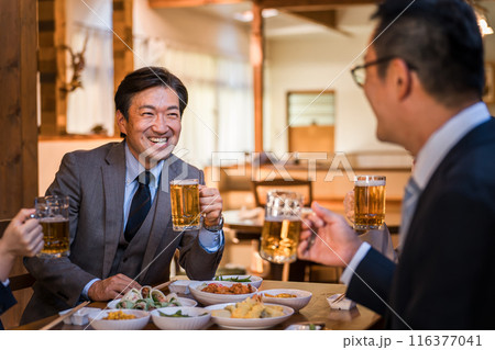 居酒屋で忘年会・新年会・飲み会・宴会をする仕事仲間・同僚・上司部下の男女 居酒屋で忘年会・新年会・飲み会・宴会をする仕事仲間・同僚・上司部下の男女 116377041