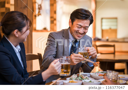 居酒屋で楽しい忘年会・新年会・飲み会・宴会をする仕事仲間・同僚・上司部下の男女 116377047