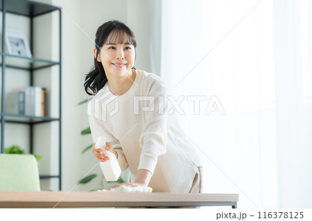 リビングで拭き掃除をする若い女性 116378125