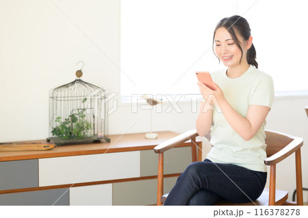 椅子に座ってスマホを操作する女性 椅子に座ってスマホを操作する女性 116378278
