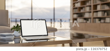 A laptop computer mockup on a modern coffee table in a contemporary luxurious living room. 116378752