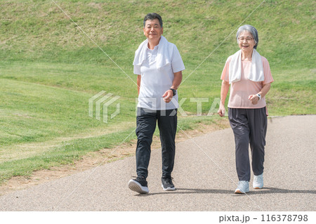 公園でウォーキング・有酸素運動する高齢者夫婦（シニア・男女） 116378798