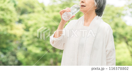 公園・森林の中でミネラルウォーターを飲むシニアのアジア人女性 116378802